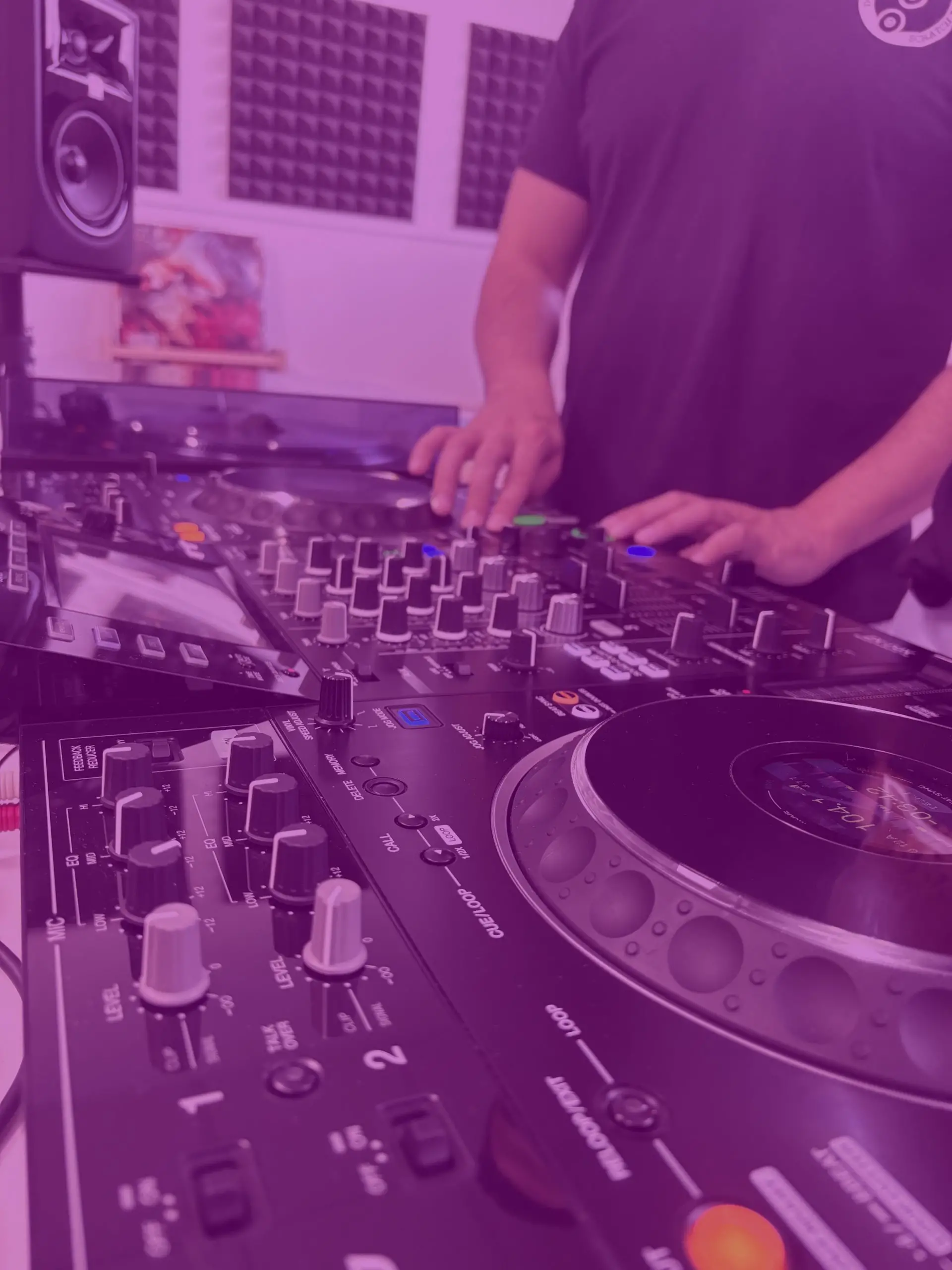 Profesor guiando una clase práctica de DJ en cabina.